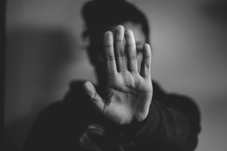 black and white photo of someone putting their hand up to say no